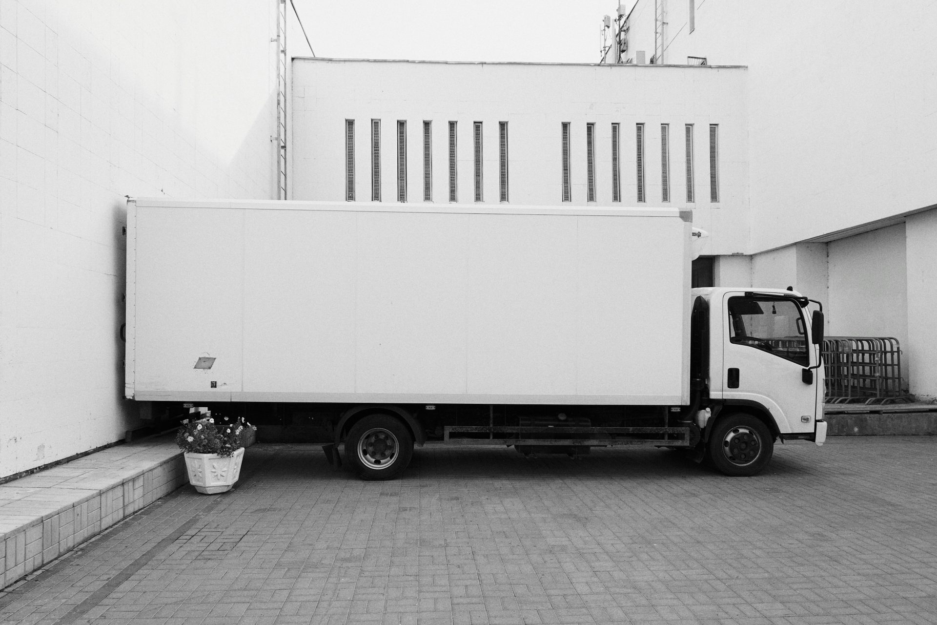 Camioneta blanca estacionada cerca de un edificio blanco.