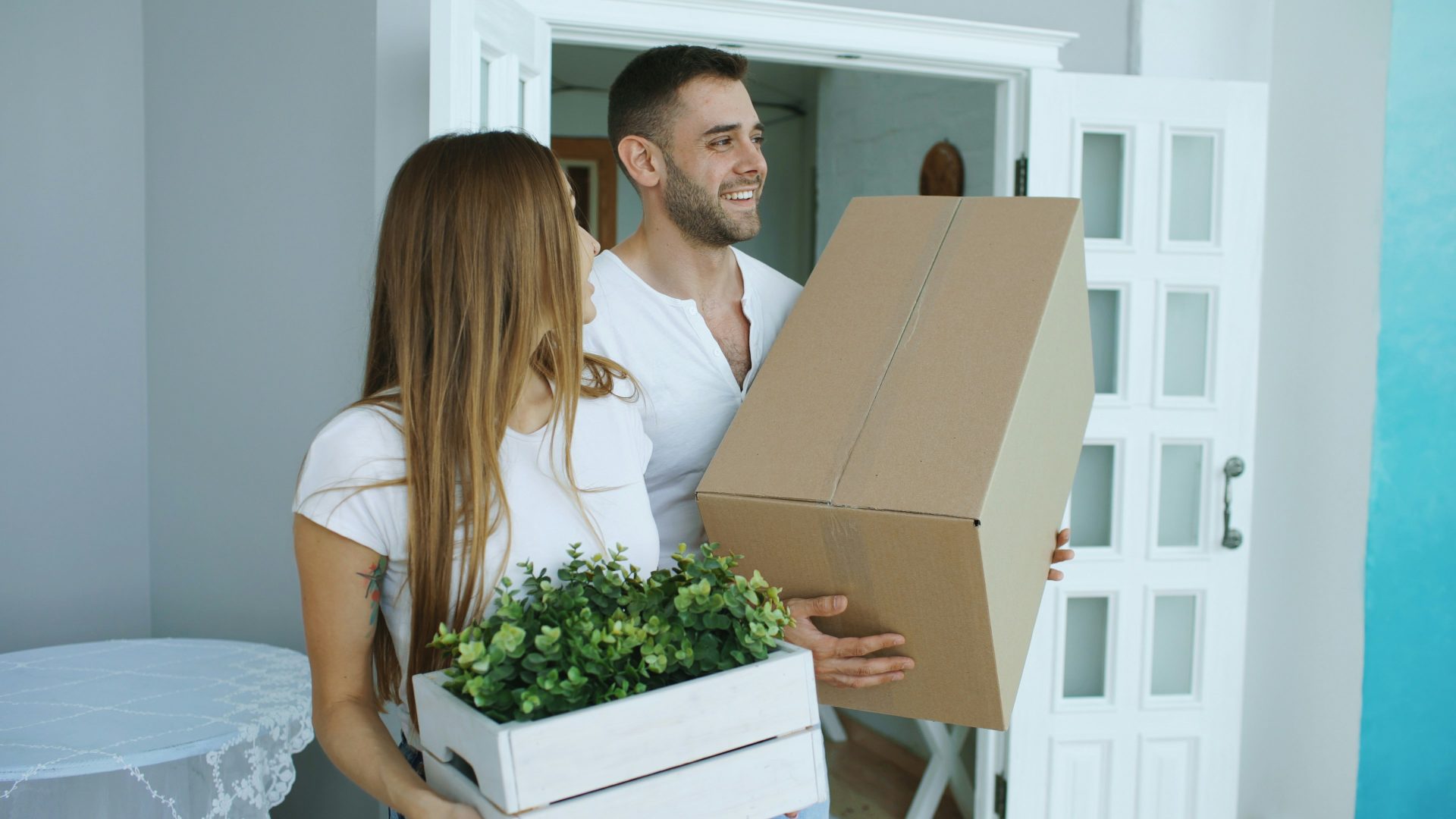 Pareja transportando cajas de mudanza a su nuevo hogar.